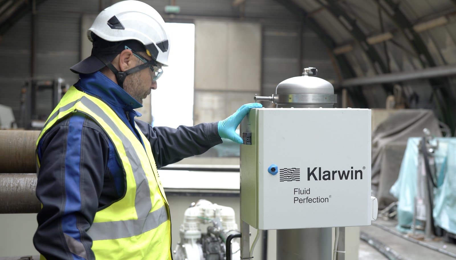 Klarwin technician operating an on-site oil purification unit branded Fluid Perfection