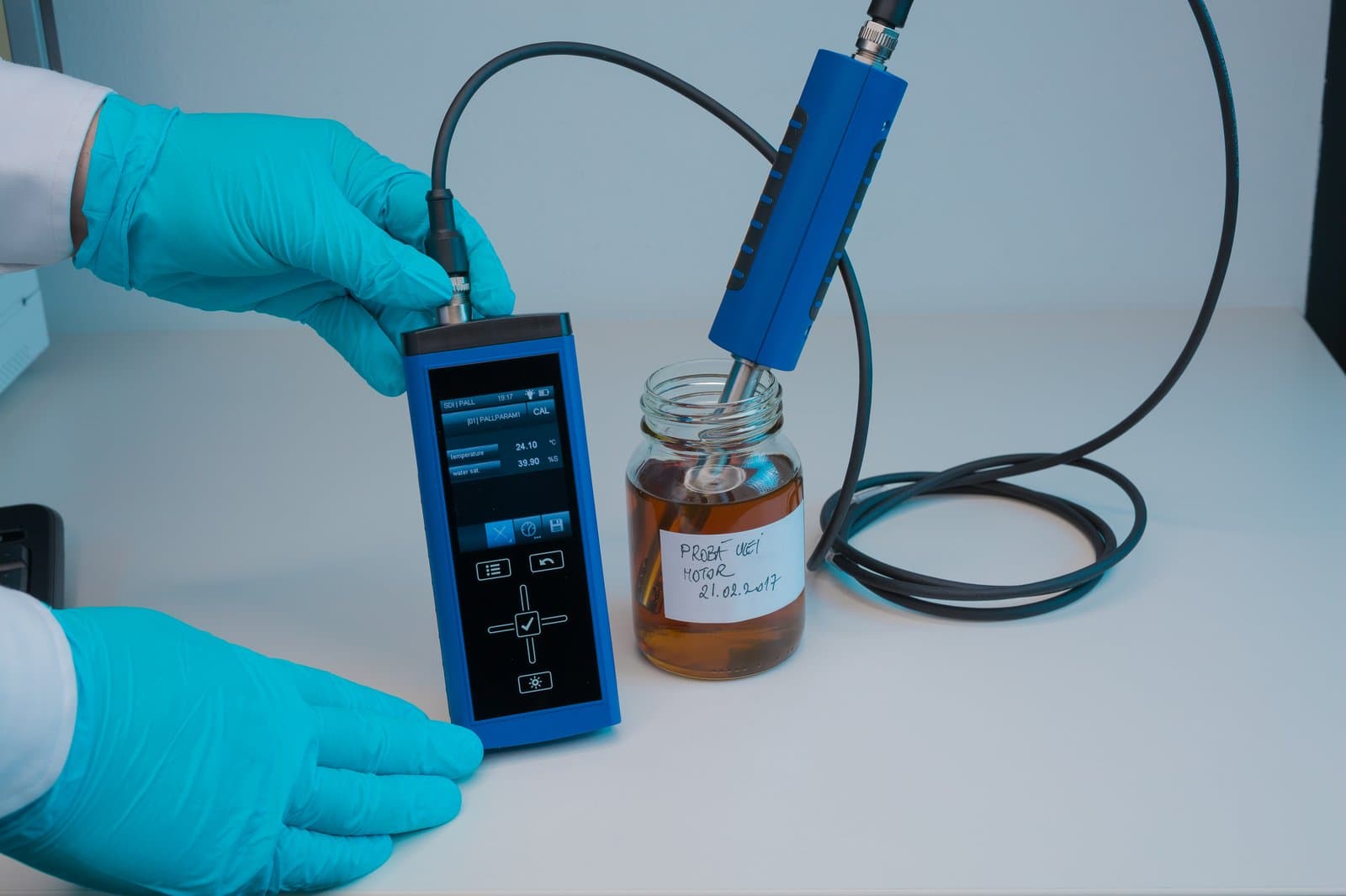 Pall handheld reader and WS07 probe measuring water content on an engine oil sample