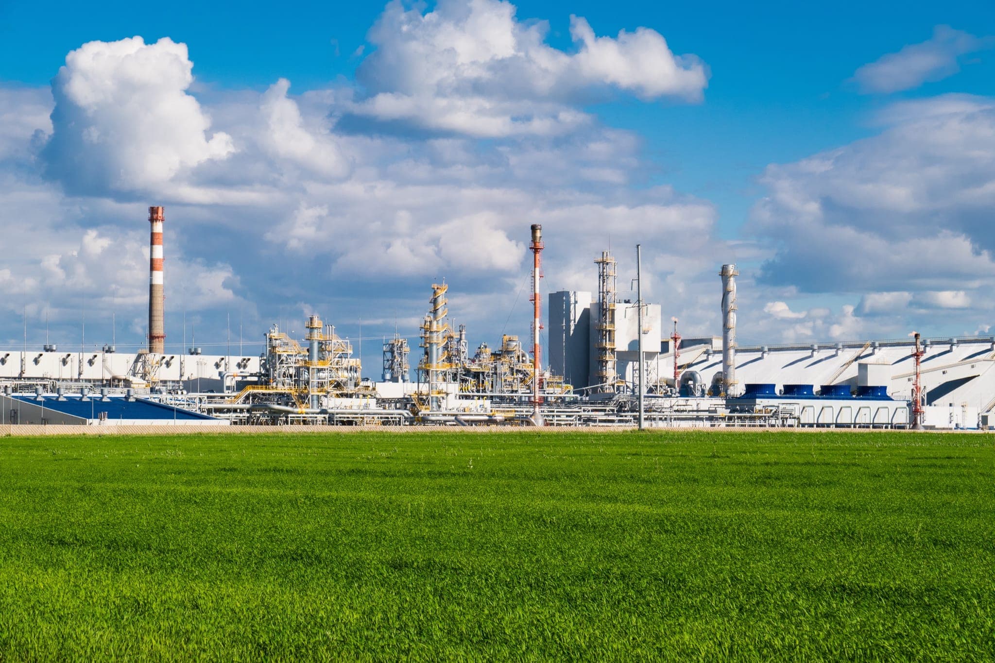 Chemical fertilizer plant with green field in the foreground