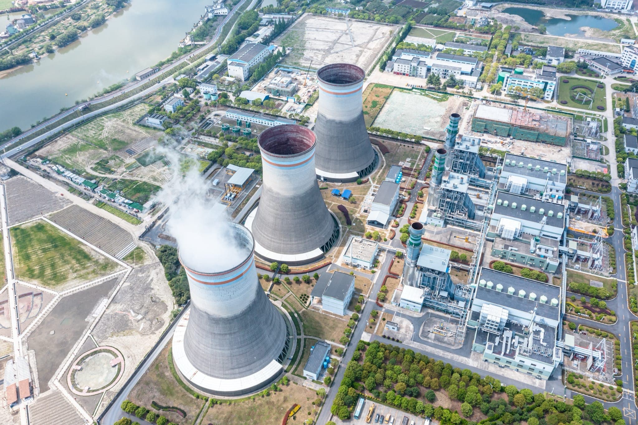 Aerial view of a thermal power plant with cooling towers and steam