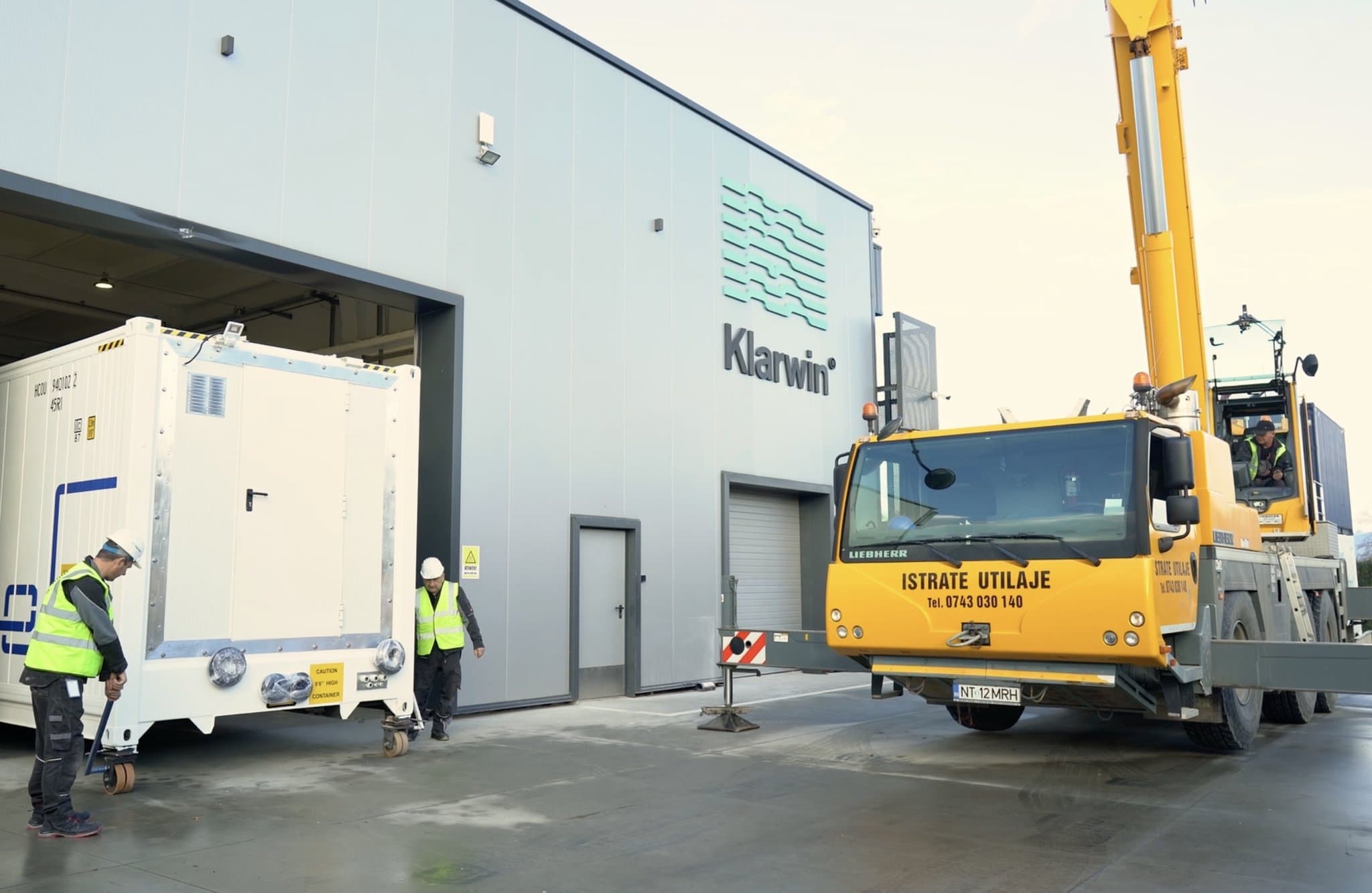 Klar100 container being loaded with a Liebherr crane in front of the Klarwin PRO building in Iernut