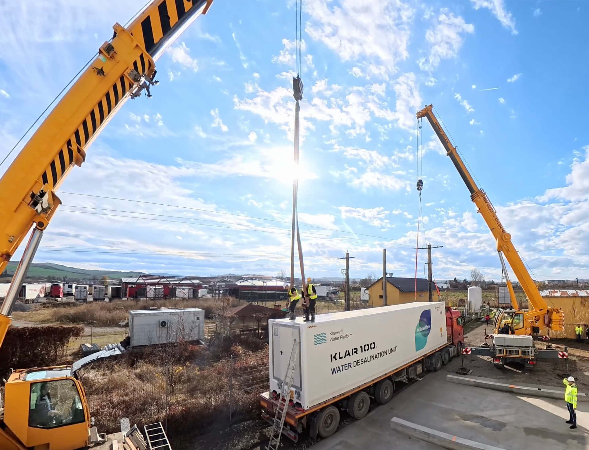 Klar100 Water Desalination Unit being lifted by cranes onto a transport truck — Klarwin Water Platform delivery