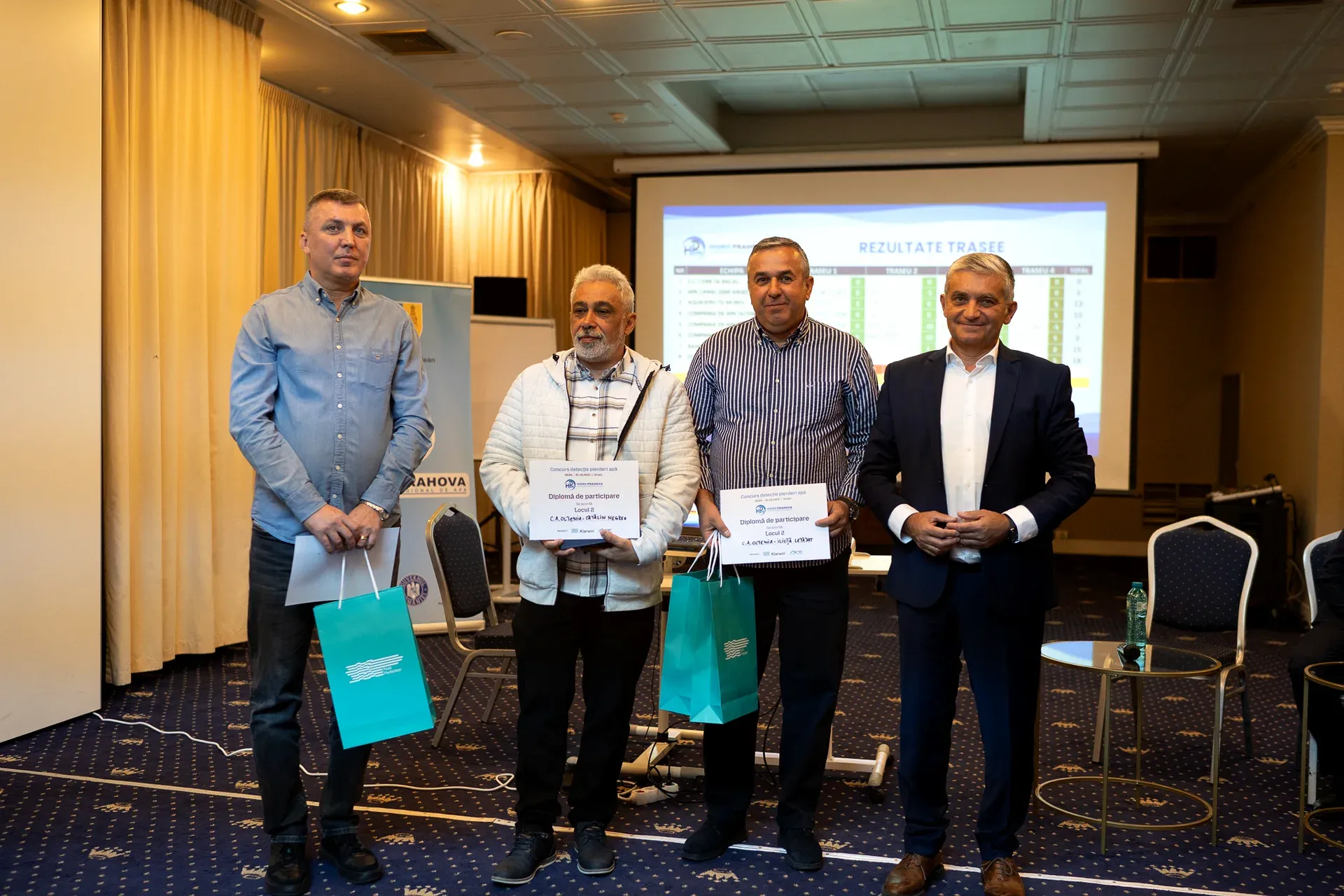 The C.A. Oltenia team receiving the second-place certificates, with the route results on screen
