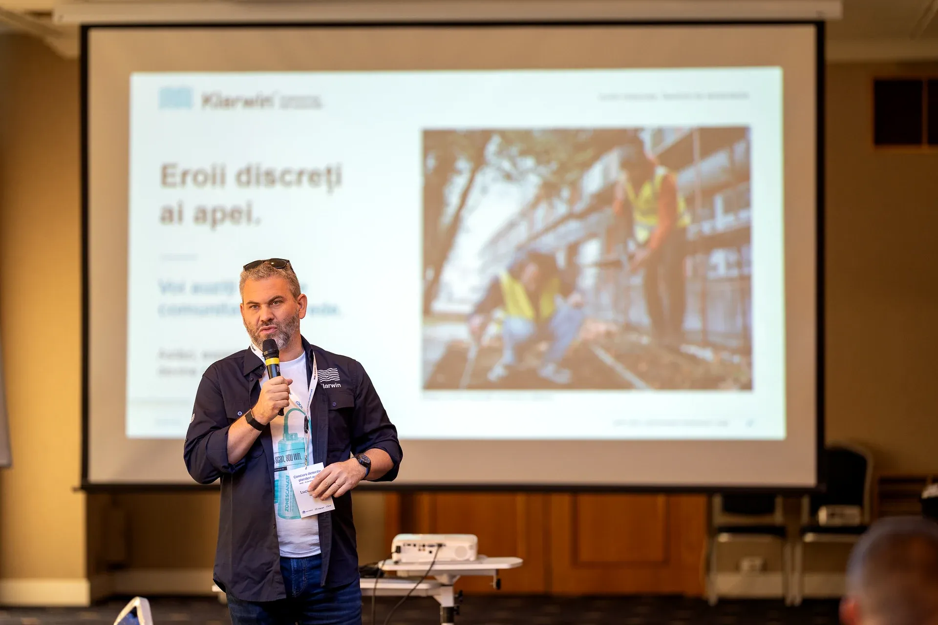 A Klarwin® speaker presenting the slide 'Eroii discreți ai apei' — the quiet heroes of water