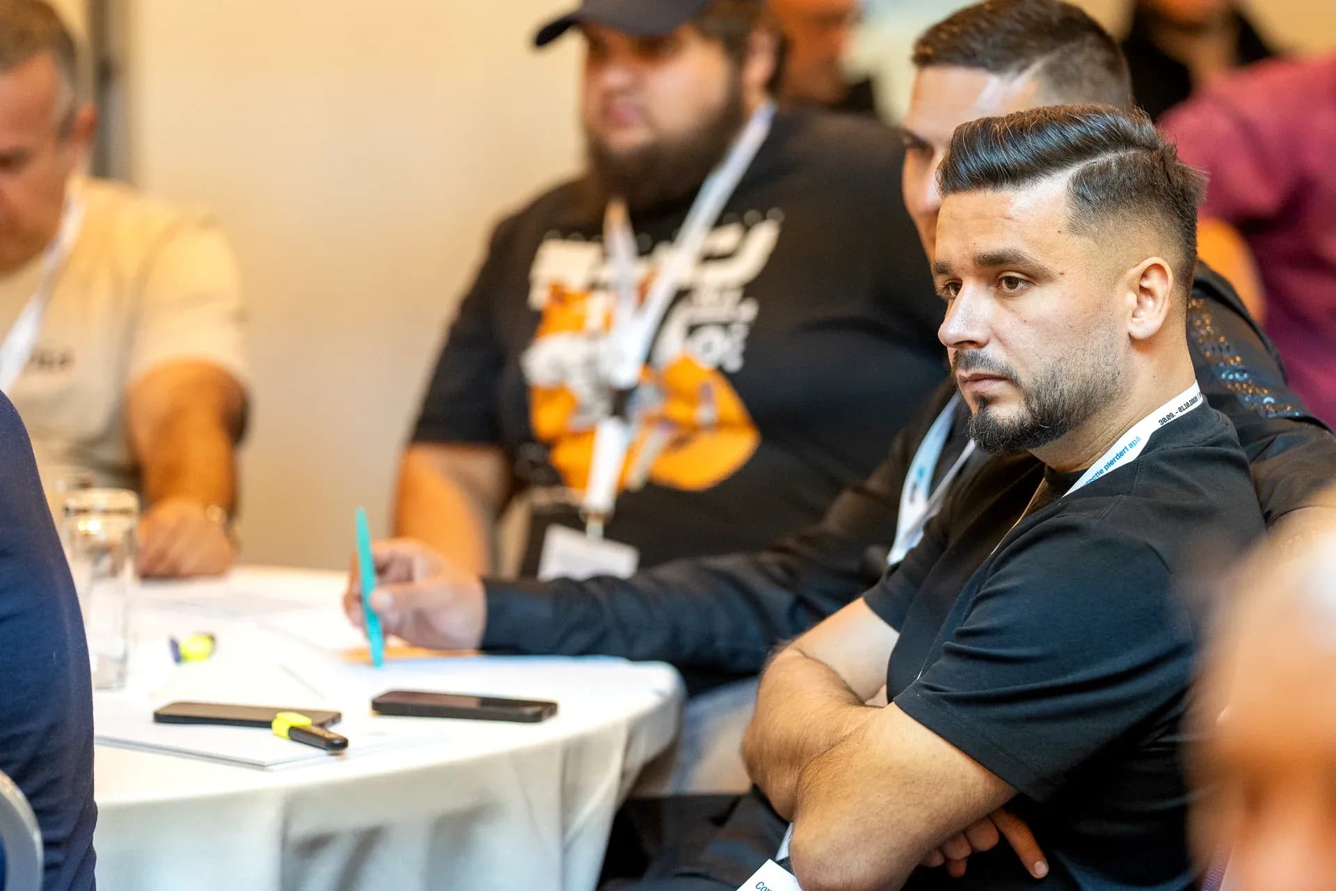 Participants following a presentation at one of the tables