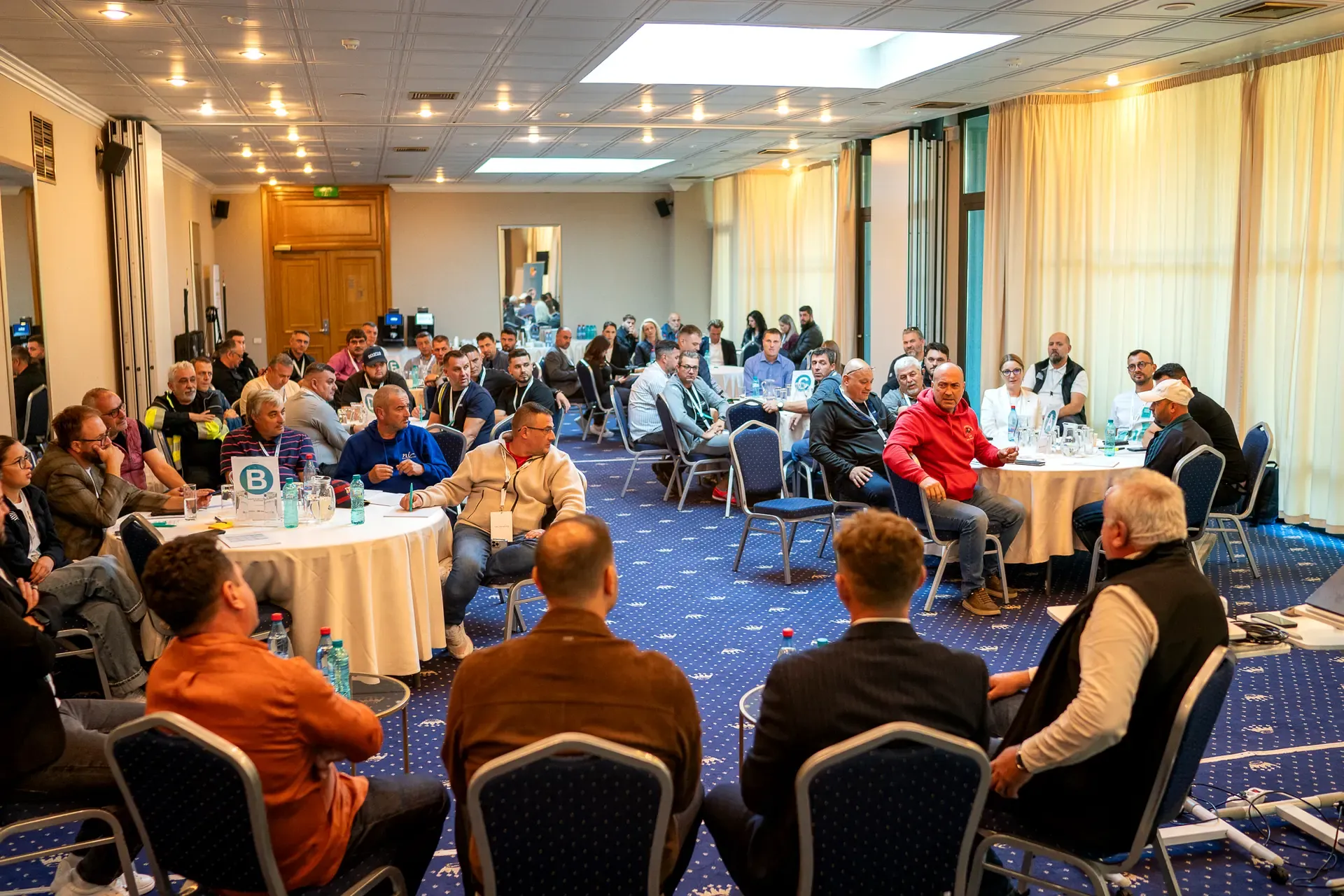 The full workshop room, with every round table occupied